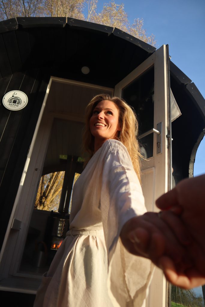 Frau auf dem Weg zur schwarzen mobilen Sauna von Seppo Sauna in Regensburg
